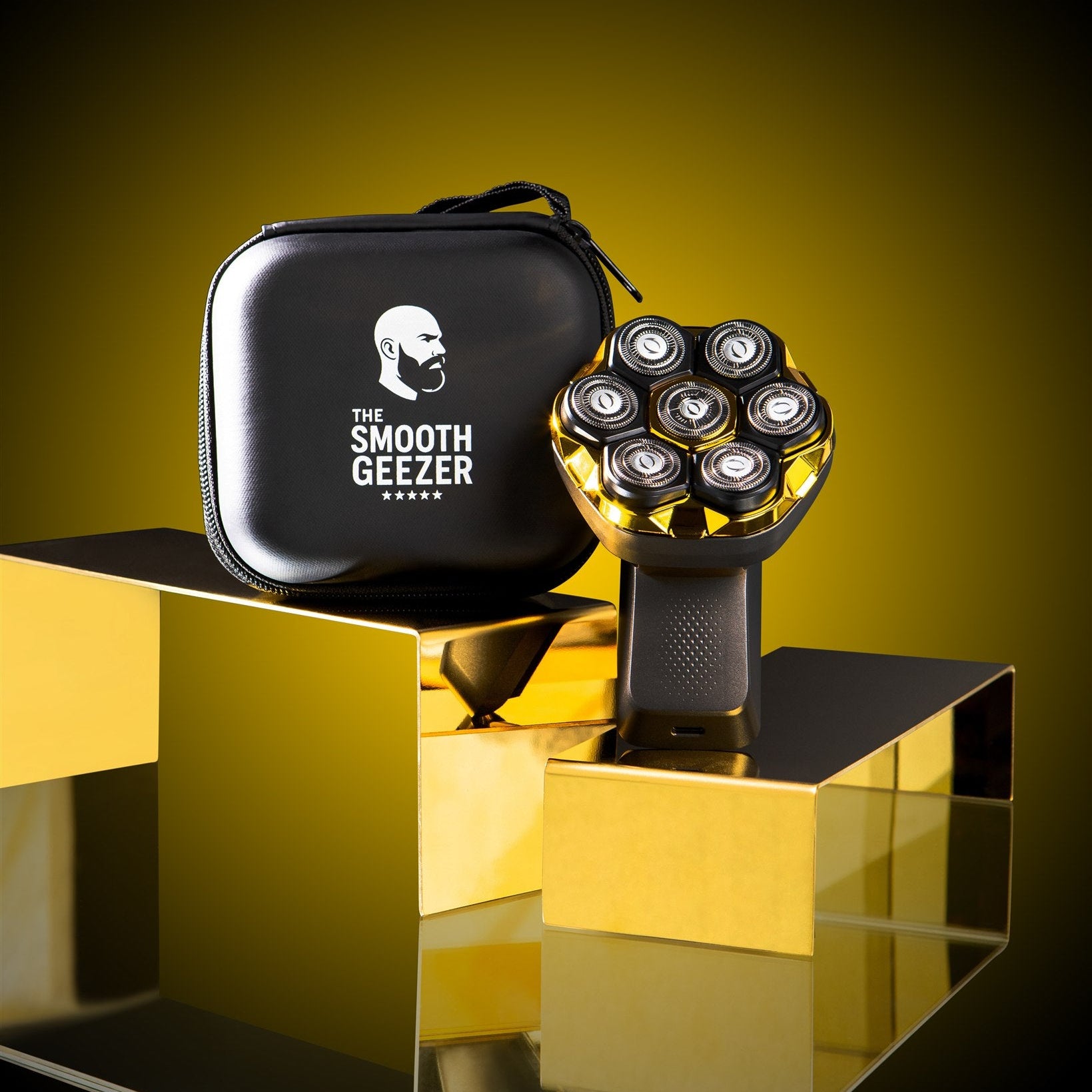 Shaving machine with black carrying case on a reflective gold surface against a yellow background